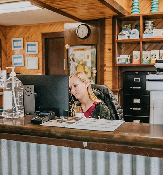 Veterinary receptionist assisting patients at the front desk of an animal hospital